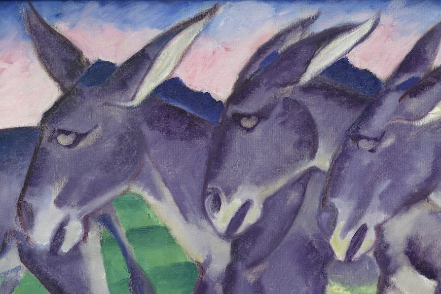 Drei Esel mit blauen und violetten Farbtönen stehen dicht beieinander vor einem Hintergrund aus grünen Feldern, blauen Bergen und einem rosa Himmel in einem abstrakten, expressionistischen Malstil.