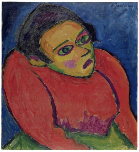 Expressionist painting of a person with a green face, large green eyes, and pink cheeks, wearing a red top and dark headscarf, set against a textured blue background. The figure looks upward with a somber expression.